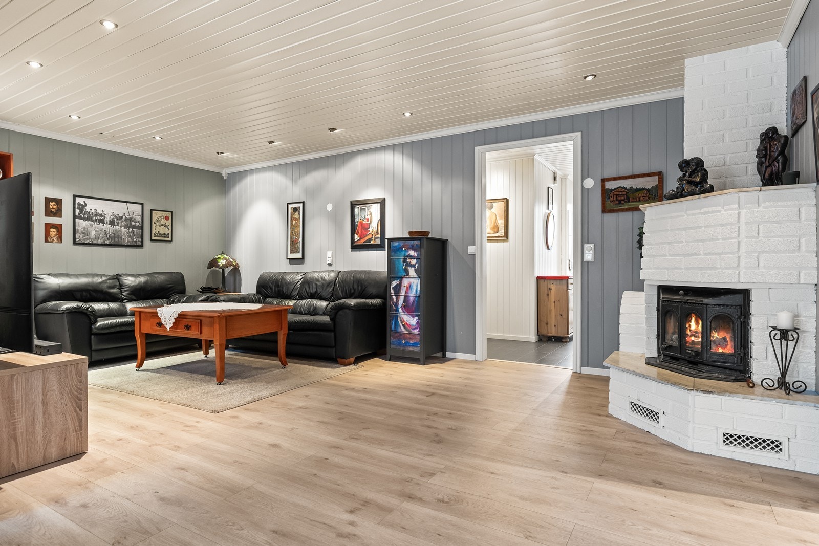 Stuen er romslig og har en hjørnemontert peisinnsats som gir god varme. Galleribilde