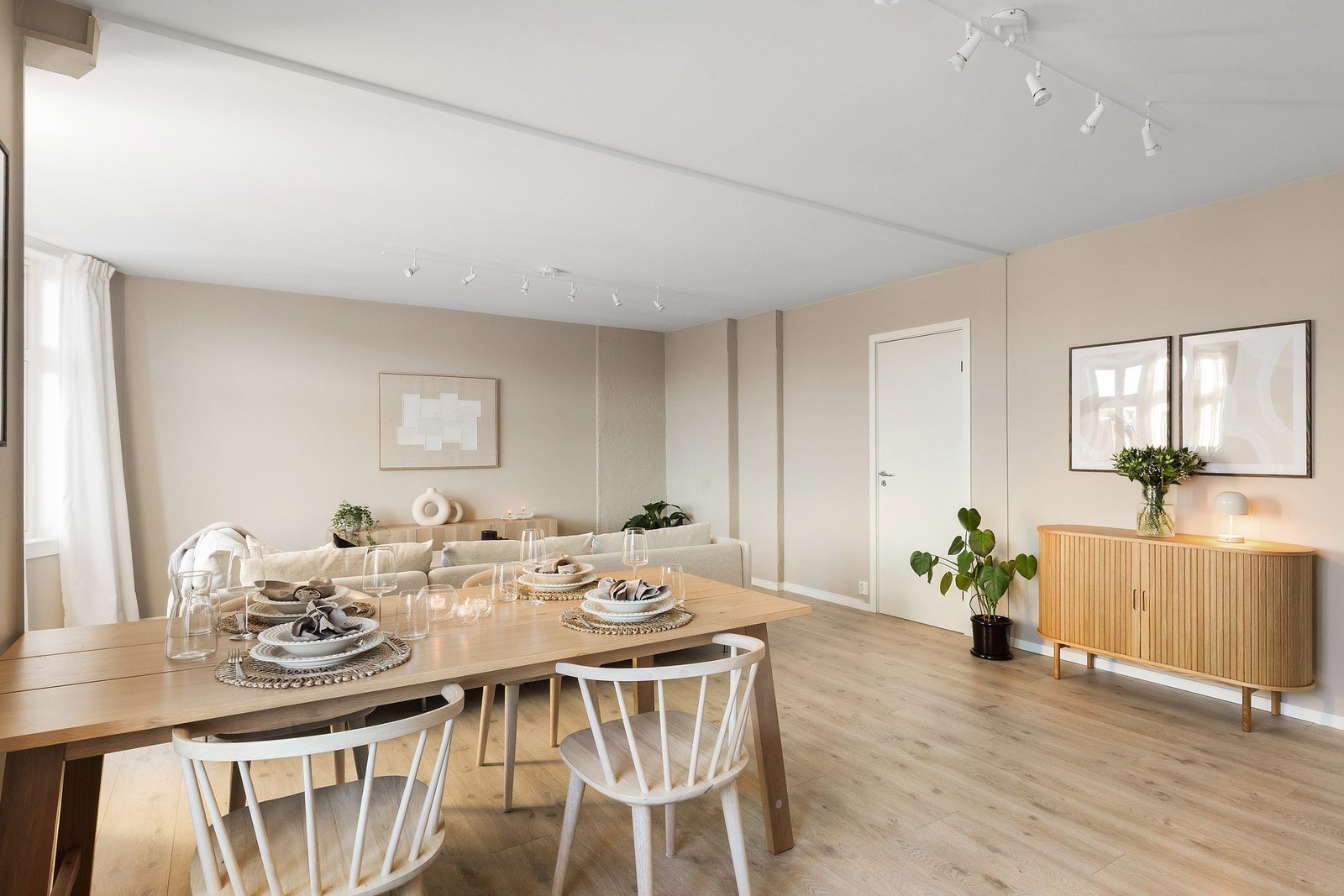 Stuen er malt i en lun beigefarge, som sammen med 1-stavs gulv gir et moderne uttrykk Galleribilde