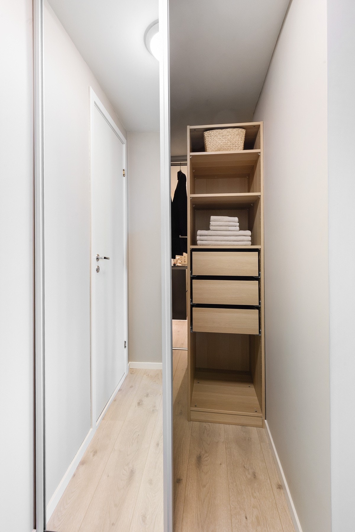 Gangen er delt inn med skyvedører og oppbevaringsmøblement på begge sider, som både brukes som bod og garderobe Galleribilde