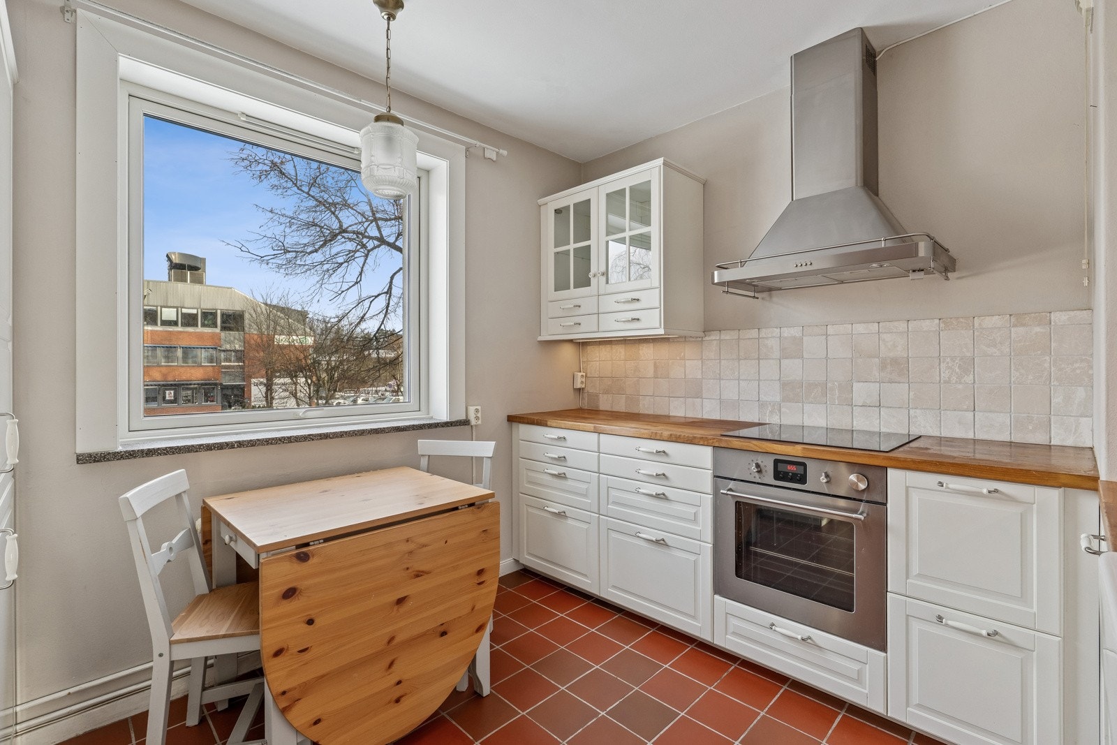 Kjøkken med fin plass til spisebord ved vinduet. Galleribilde