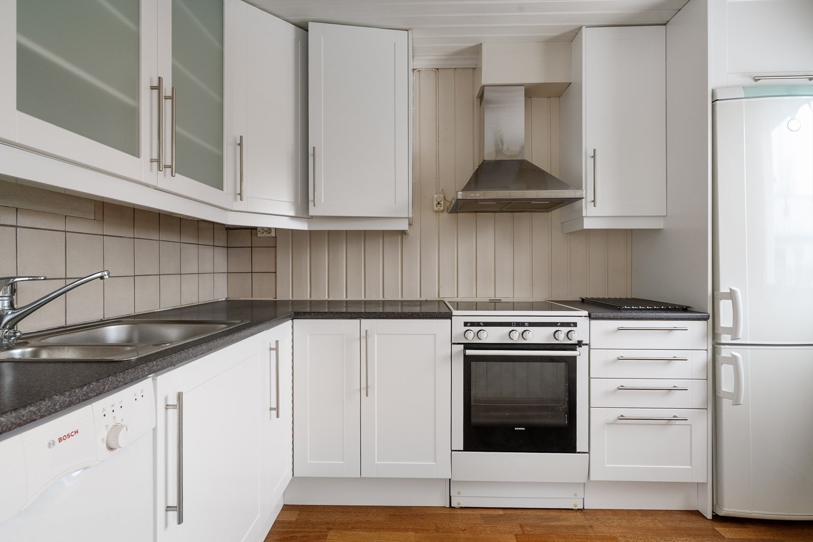 Leiligheten har hvit kjøkkeninnredning fra 2009 med god oppbevaringsplass i takhøye overskap med innslag av glass-skap. Galleribilde