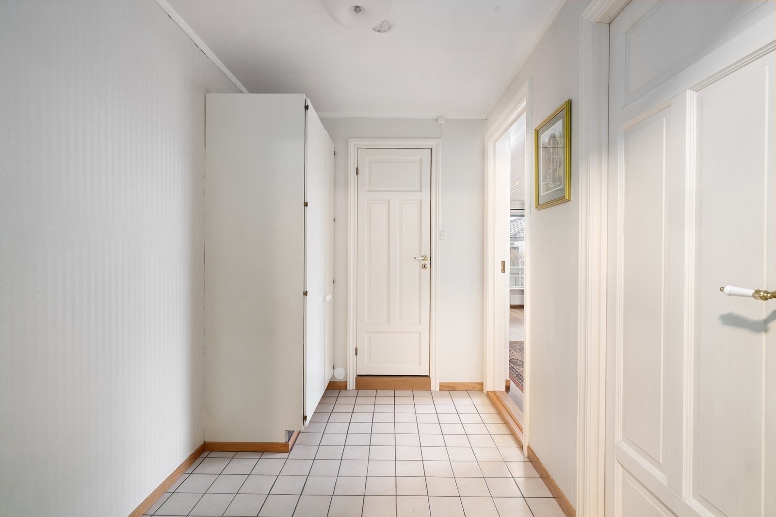 Med adkomst fra felles trappegang kommer man inn i leilighetens entrè som er av god størrelse, med flislagt gulv og stort garderobeskap for klesoppbevaring. Galleribilde