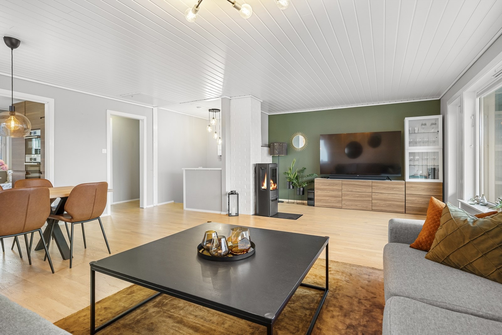 Lune kvelder sikres av en peisovn, plassert slik at stemningen nytes fra både sofakroken og spiseplassen. Galleribilde