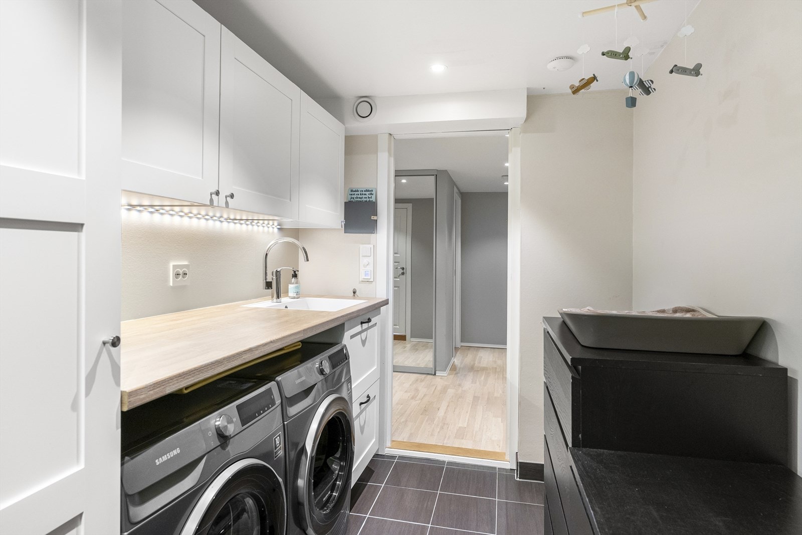 Under benken har rommet opplegg for vaskemaskin og plass til tørketrommel. Galleribilde