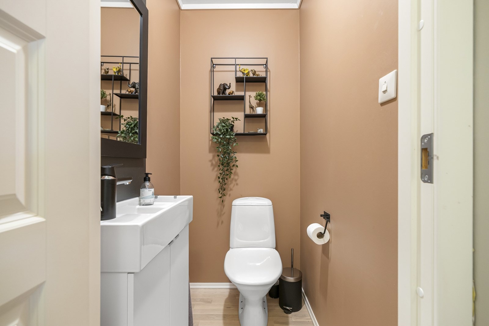 Utenom toalettet har wc-rommet lyst parkettgulv og et hvitt servantskap med tilhørende speil. Galleribilde