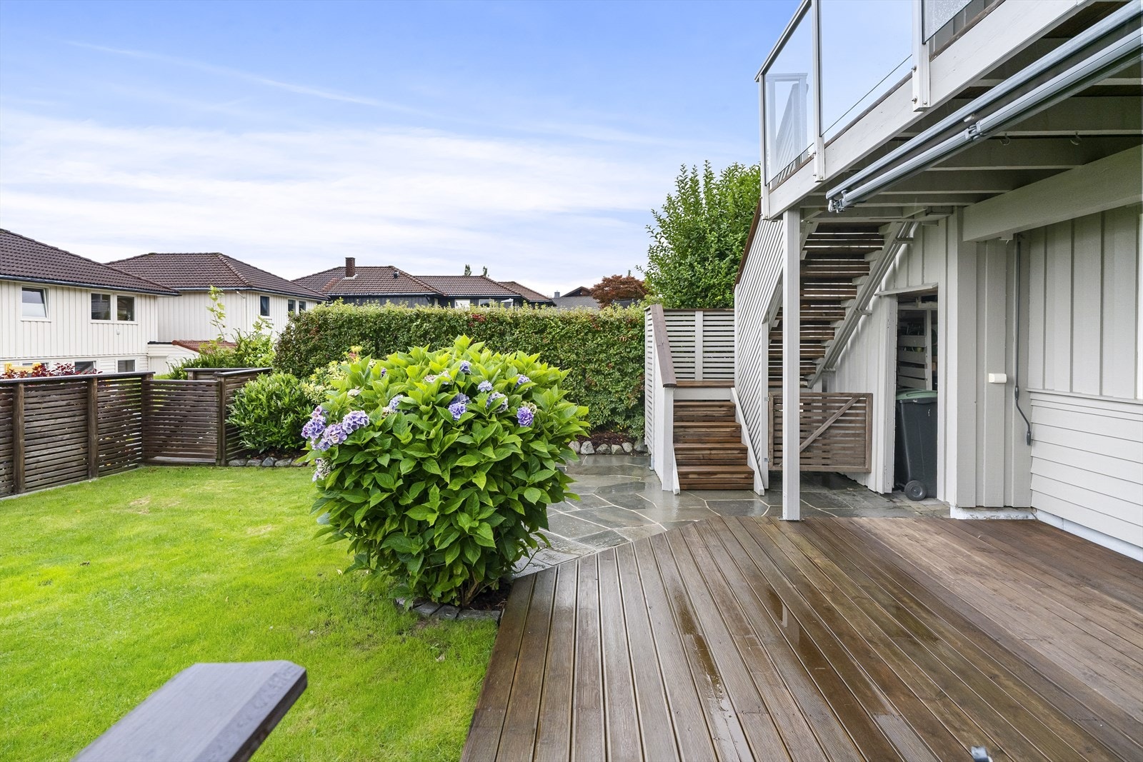 En trapp tar deg ned til hagen og en trivelig terrasse. Terrassen er delvis overbygd, med et areal på ca. 24 kvm. Størrelsen gir flere soner til ulikt bruk, og uterommet innbyr til stille stunder så vel som lange, sosiale kvelder. Galleribilde