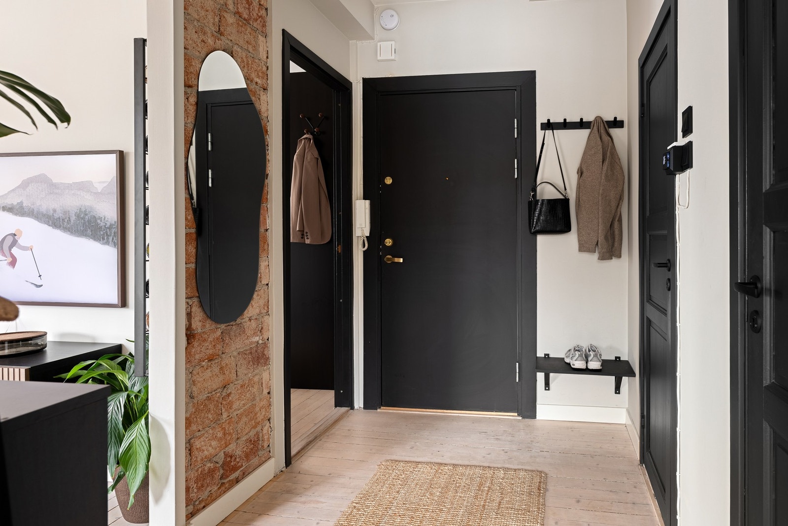 Lysmalte vegger, synlig teglstein og tregulv i entreen gir et lyst og trivelig førsteinntrykk. Galleribilde