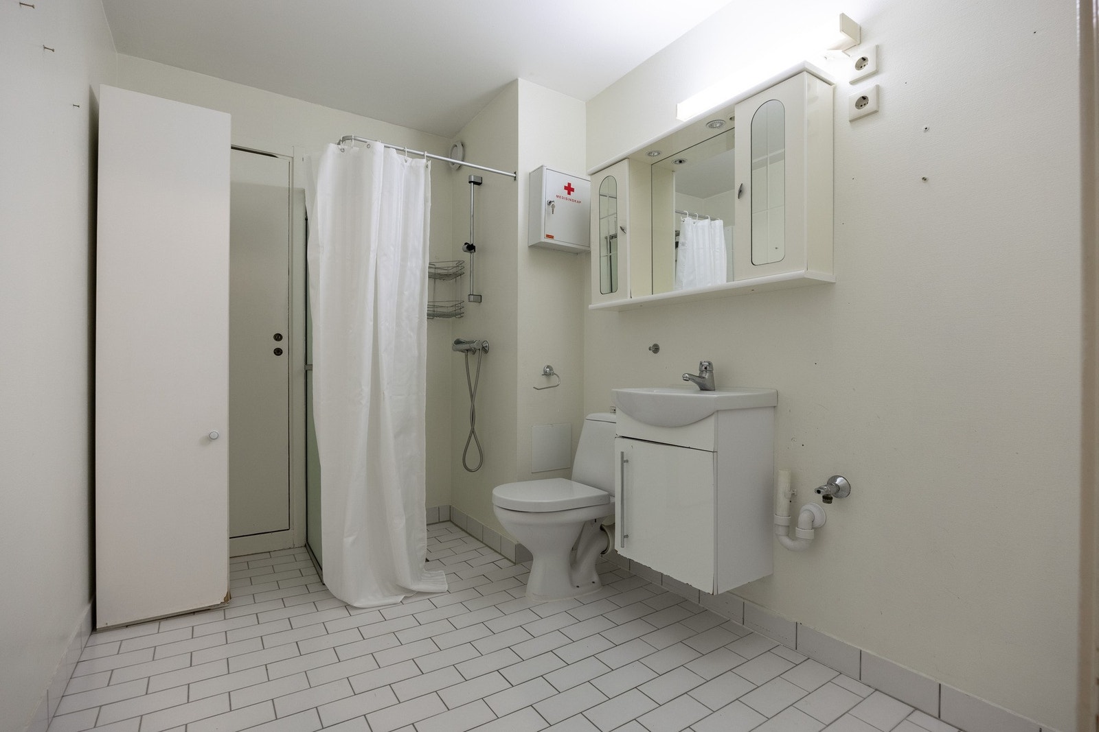 Romslig og praktisk baderom med flislagt gulv. Galleribilde