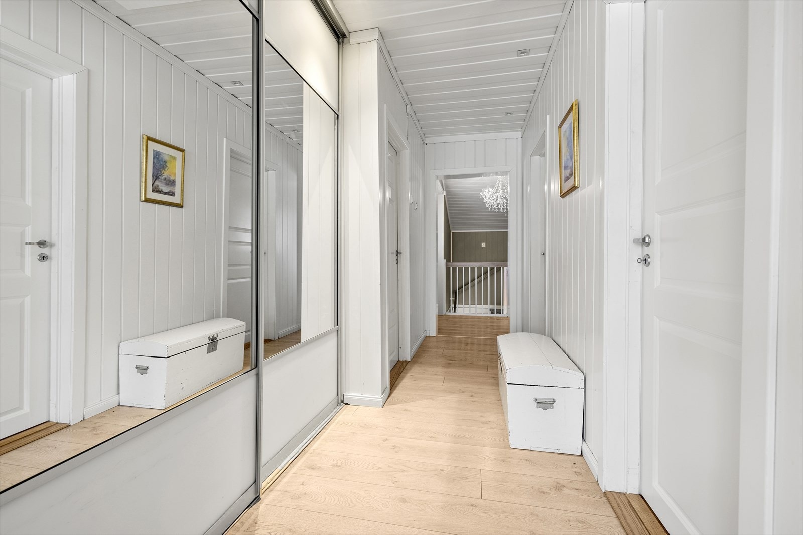 Gang med praktisk skyvedørsgarderobe som leder inn til boligens tre soverom og bad, samt ned til kjeller. Galleribilde
