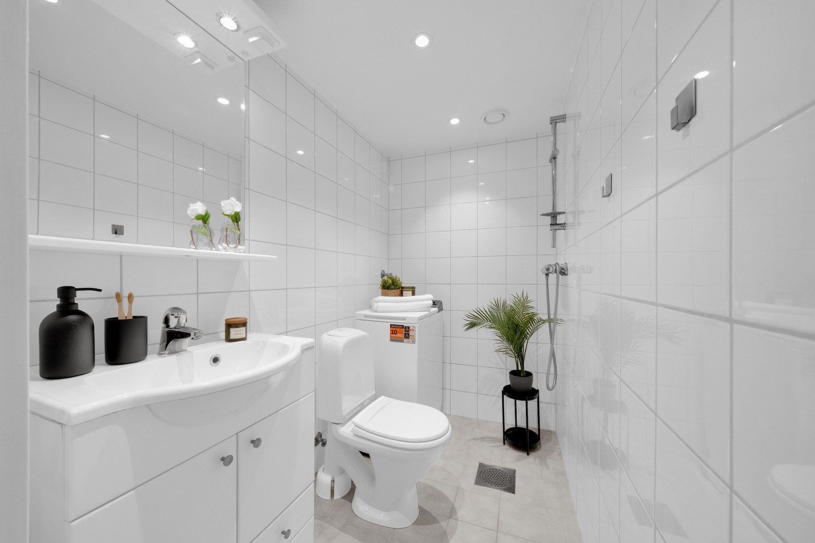 Badet har flislagte vegger og flislagt gulv med varmekabler, kombinert med malt tak med innfelte downlights som gir et moderne og behagelig uttrykk Galleribilde