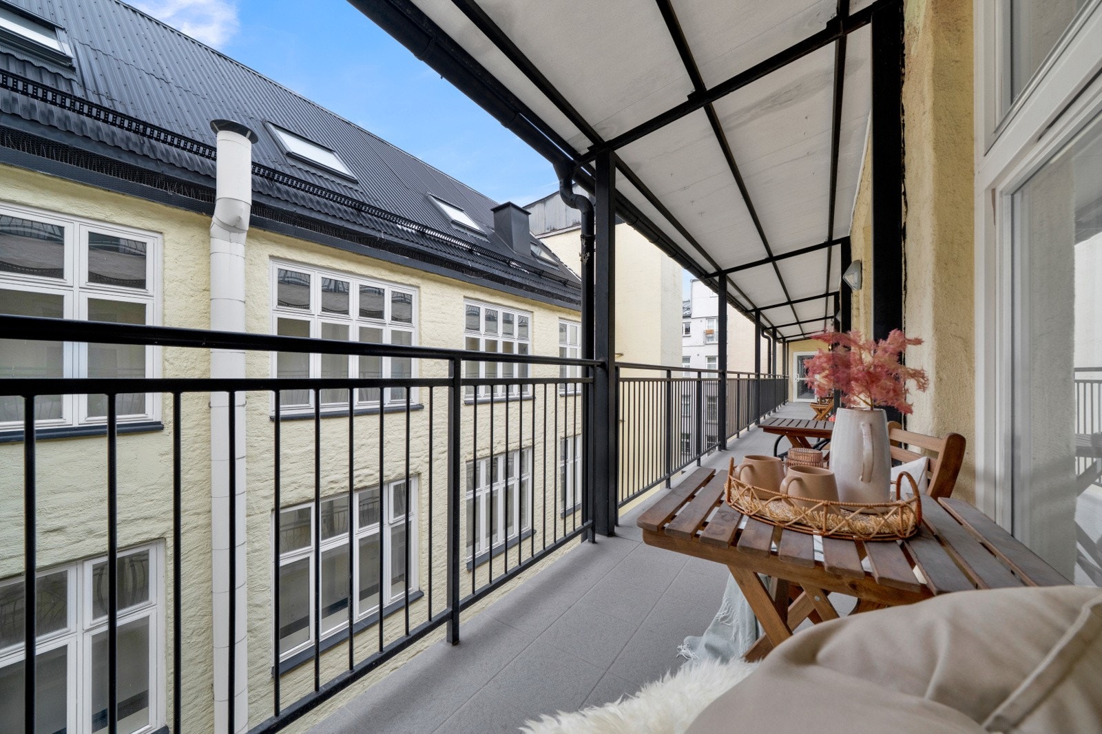 Smalgangen utenfor fungerer for de fleste i borettslaget som balkonger med fint utemøblement, planter og blomster Galleribilde