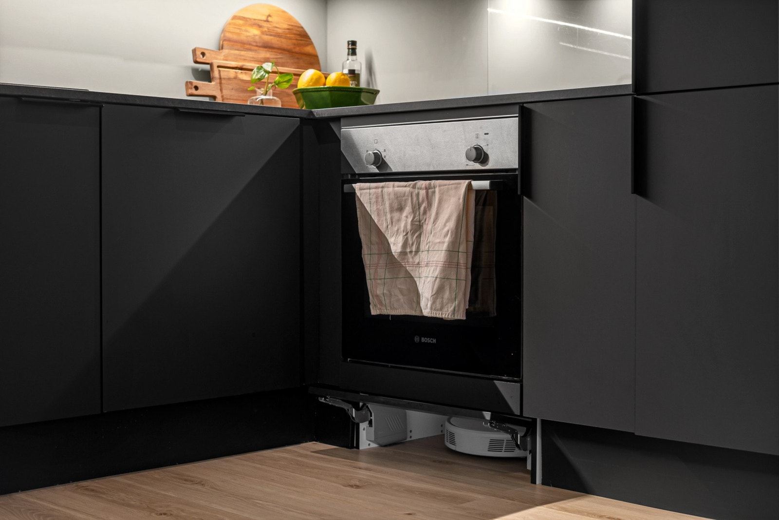 Innredningen er tilrettelagt for enkel rengjøring: en hengslet dør ved sokkellisten til robotstøvsugeren. Galleribilde