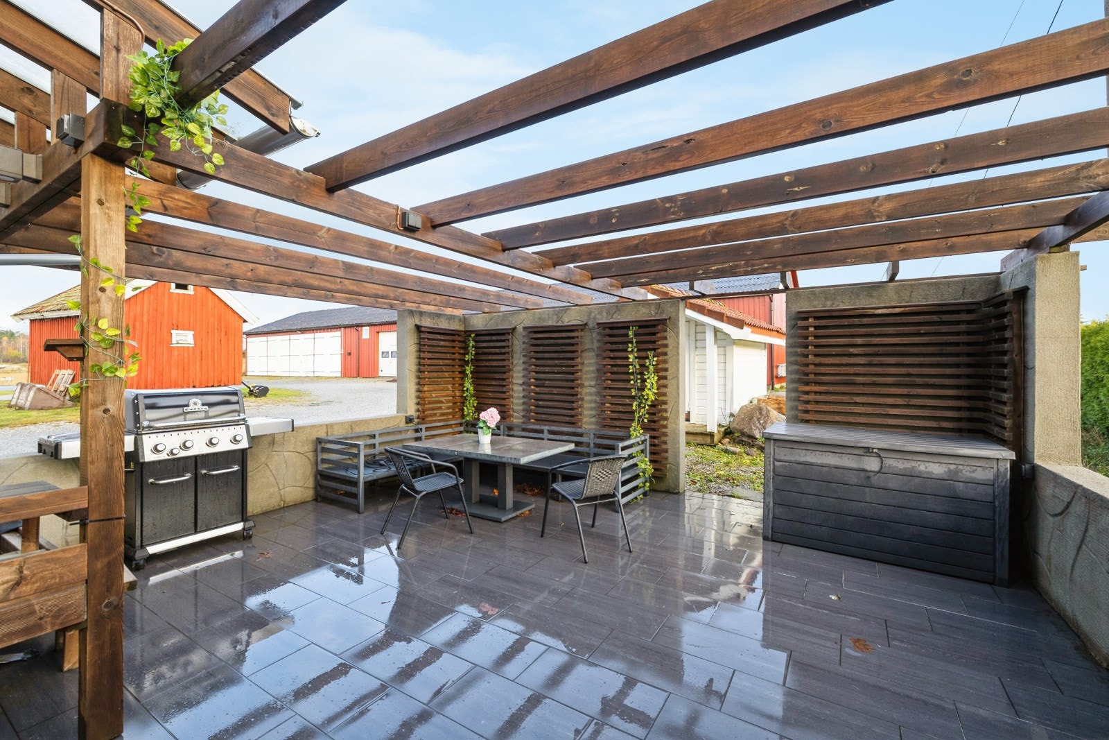 Koselig grillplass med pergola og flislagt gulv ved hovedhuset Galleribilde