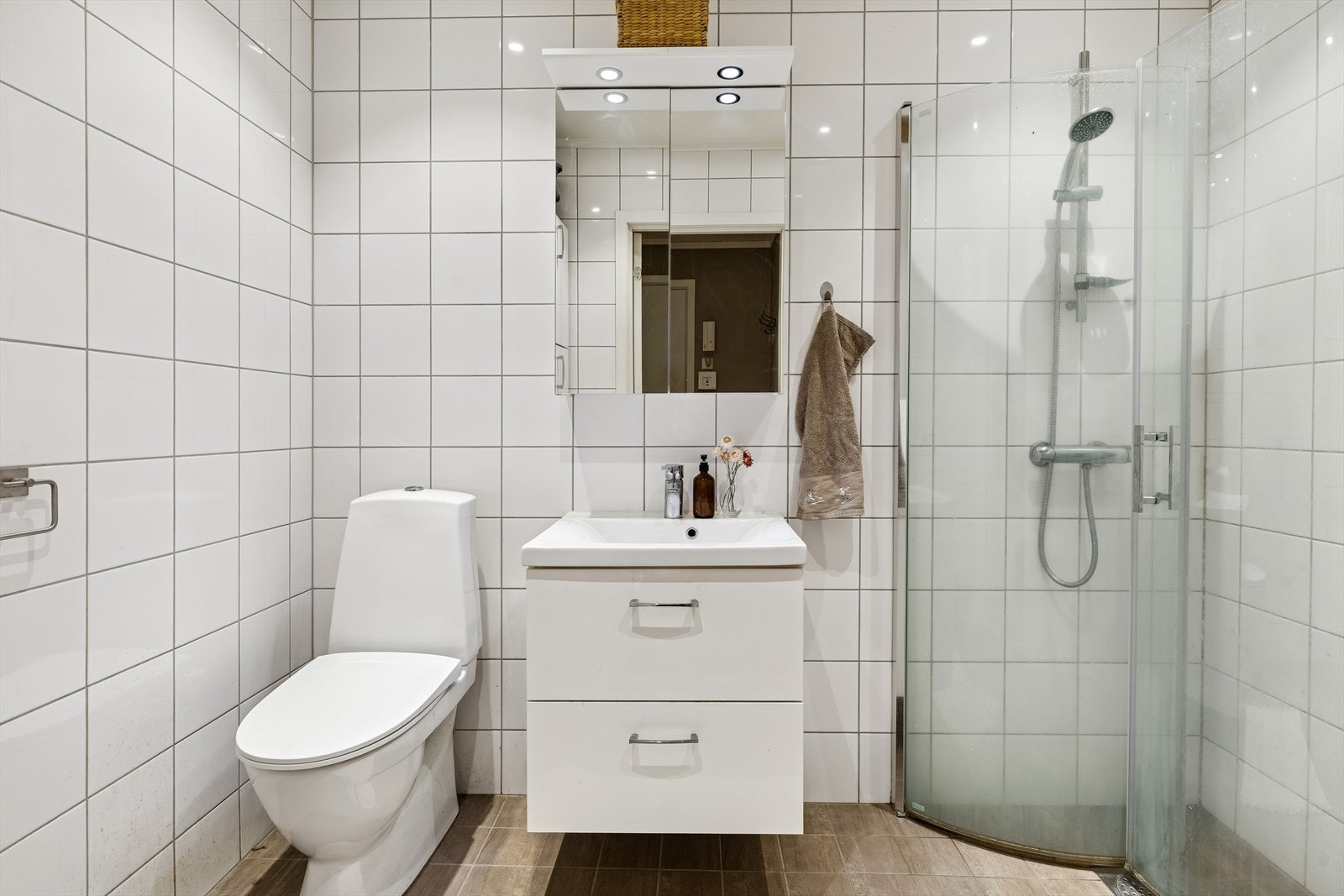 Lyst og pent bad med fliser med varme i gulv, fliser på vegger og slett malt tak m/downlights. Galleribilde