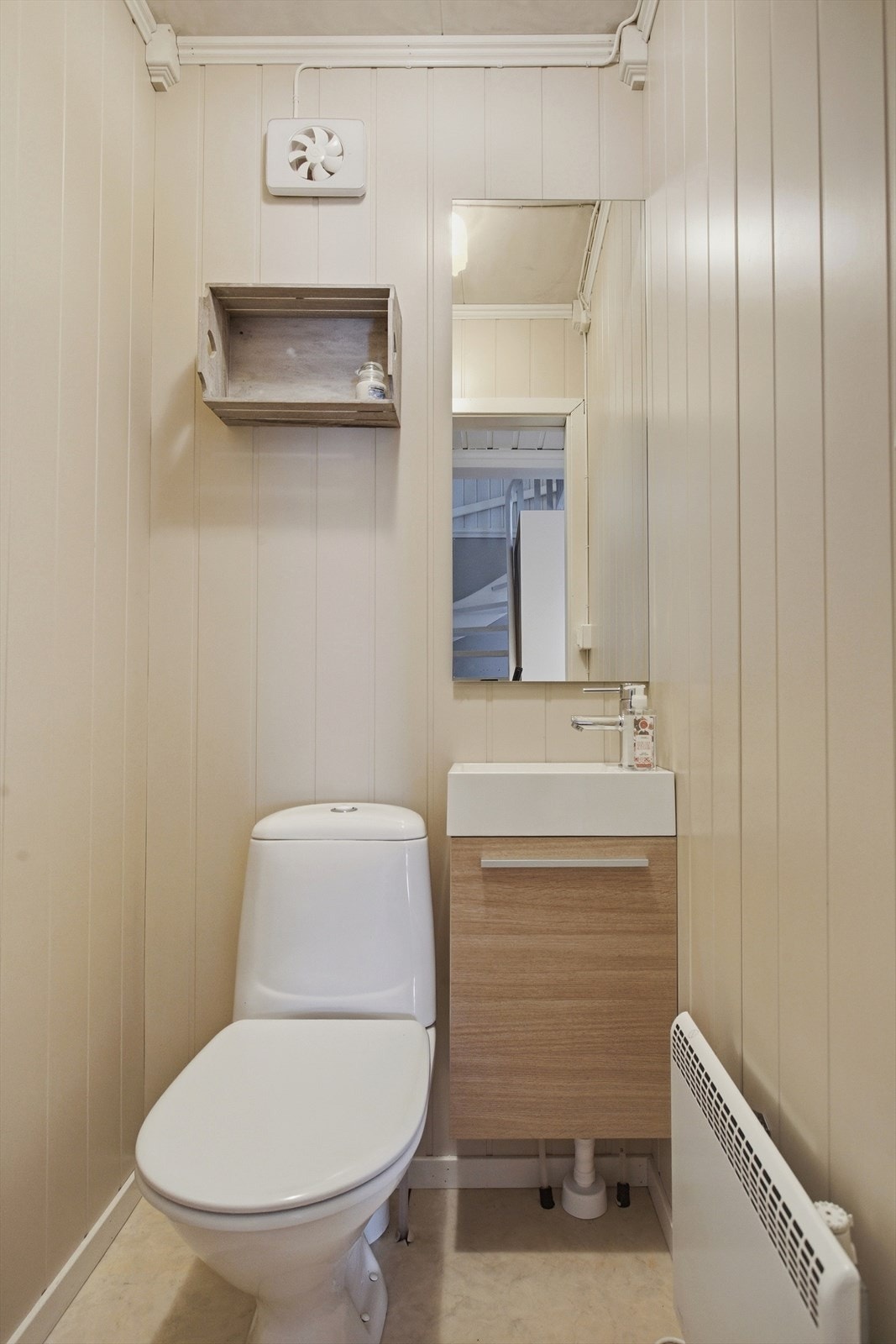 Enkelt innredet toalettrom med servant og toalett. Galleribilde