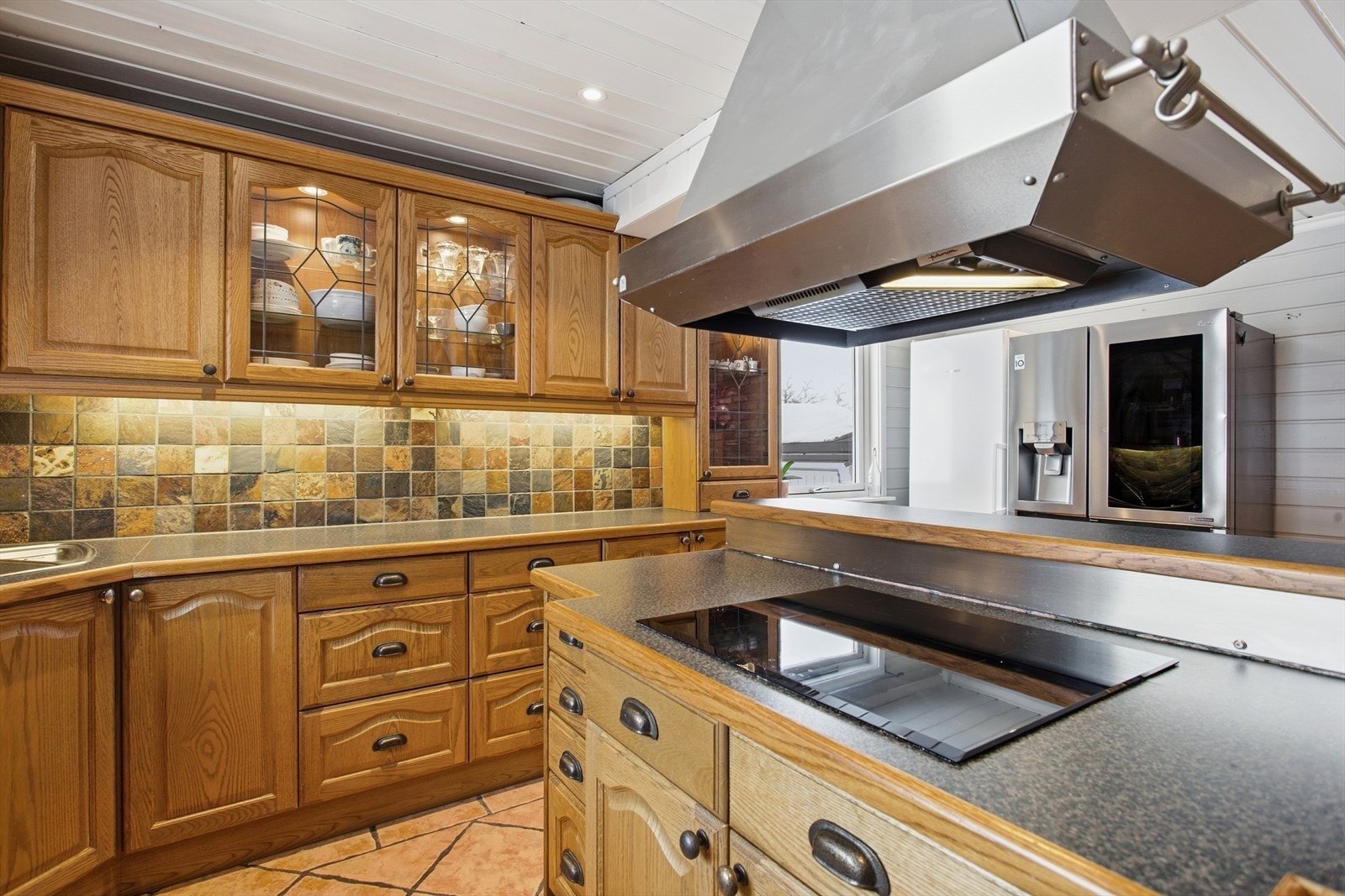 Kjøkkenet har innredning med profilerte fronter. Benkeplaten er av laminat med heltre frontlist. Galleribilde