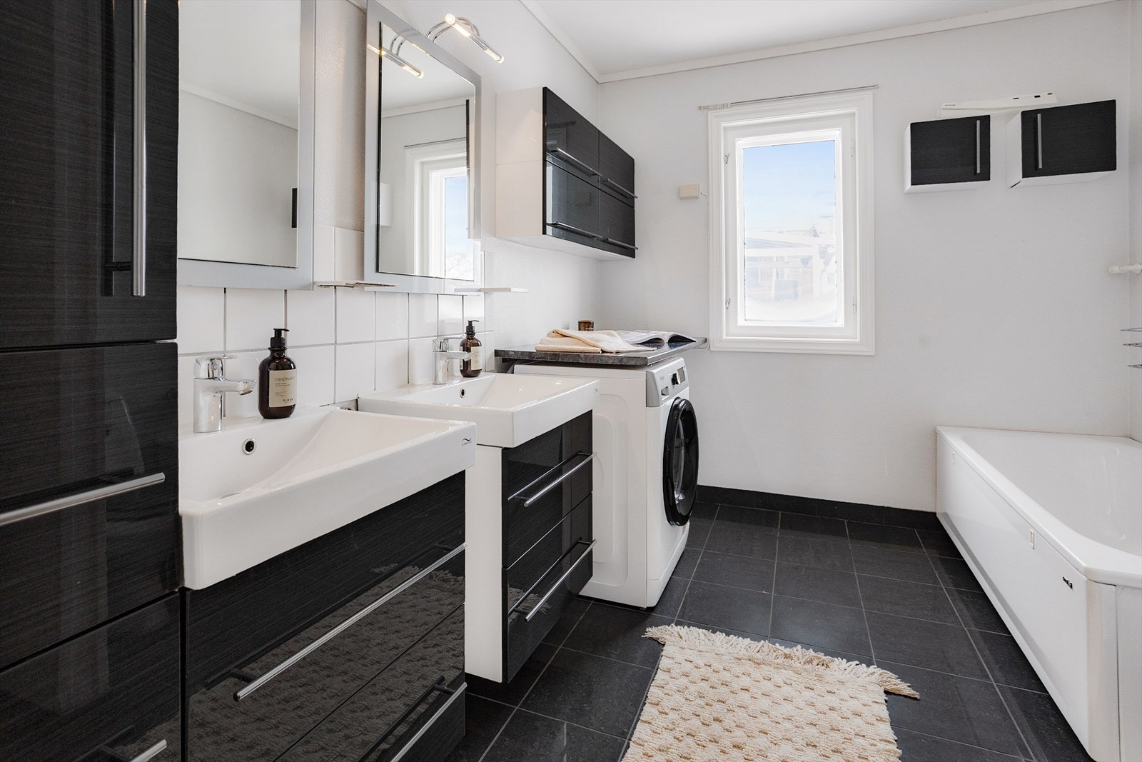 Badet er utstyrt med to innredninger med servant, toalett, badekar, dusjnisje og opplegg for vaskemaskin Galleribilde