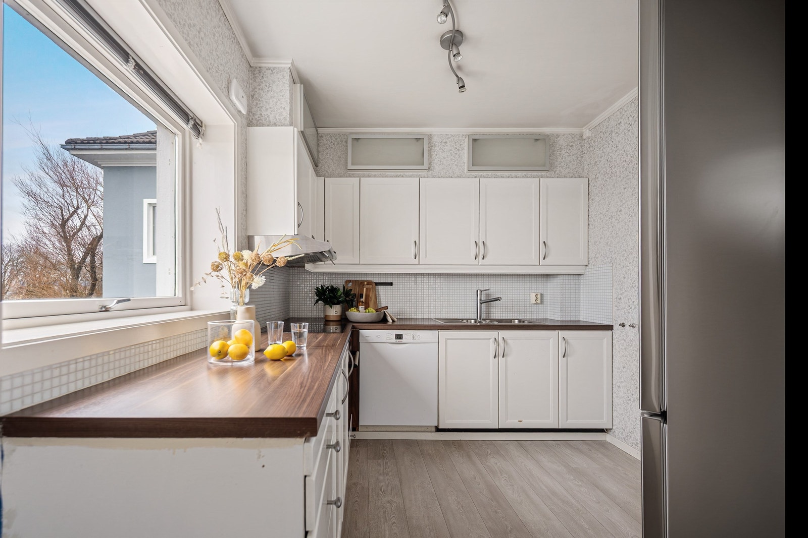 Kjøkkenet er i tidløse hvite farger, profilerte fronter og brun benkeplate. Galleribilde