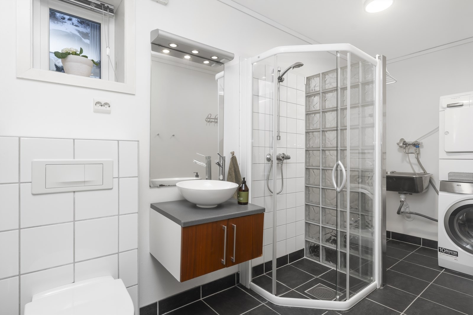 Badet i 1. etg. er praktisk kombinert med vaskerom og har flislagt gulv med vannbåren gulvvarme Galleribilde