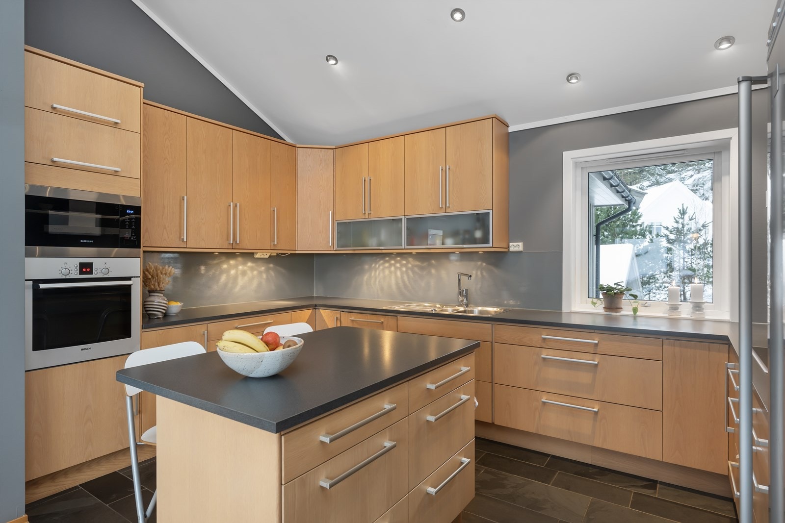 Kjøkkenet har integrerte hvitevarer som kjøleskap, oppvaskmaskin, platetopp, mikrobølgeovn og stekeovn Galleribilde