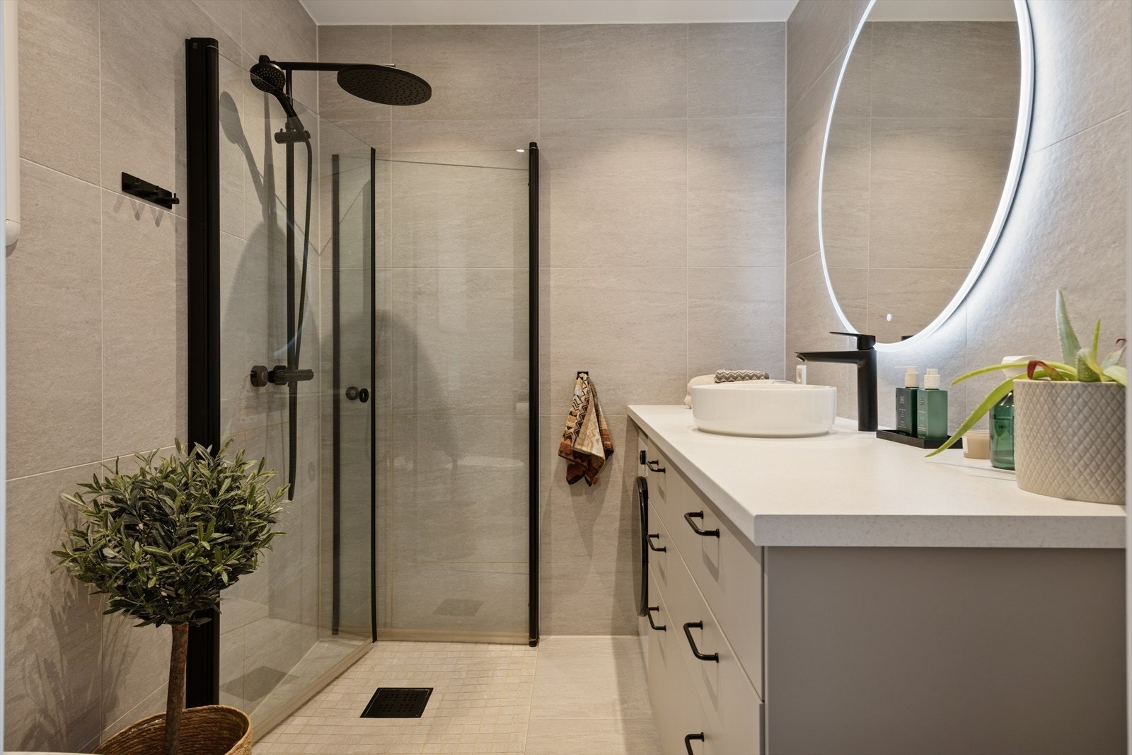 Innfellbare dusjvegger, vannfalldusj og lekre sorte detaljer gir baderommet et smakfullt preg. Galleribilde