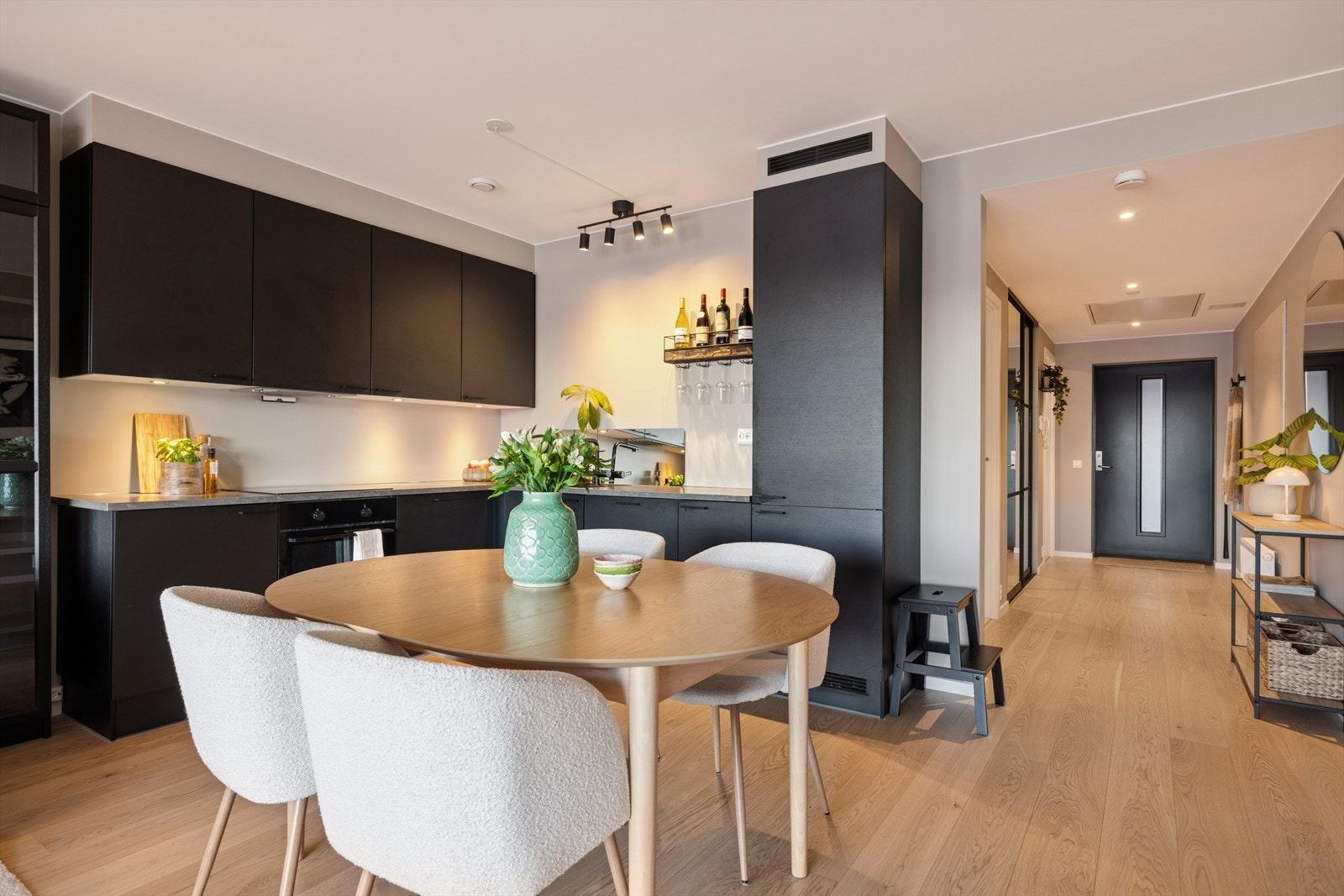 Kjøkkenet har en moderne og elegant innredning i mørke farger med glatte, stilrene fronter som gir et tidløst uttrykk. Galleribilde