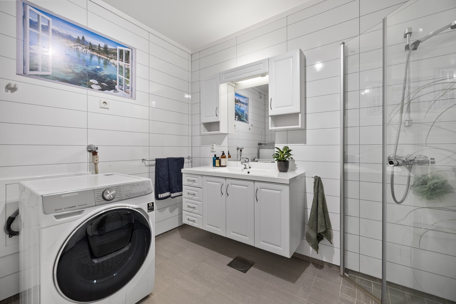 Rommet er innredet med servant, vegghengt toalett og dusjhjørne med vegger, samt opplegg for vaskemaskin. Galleribilde