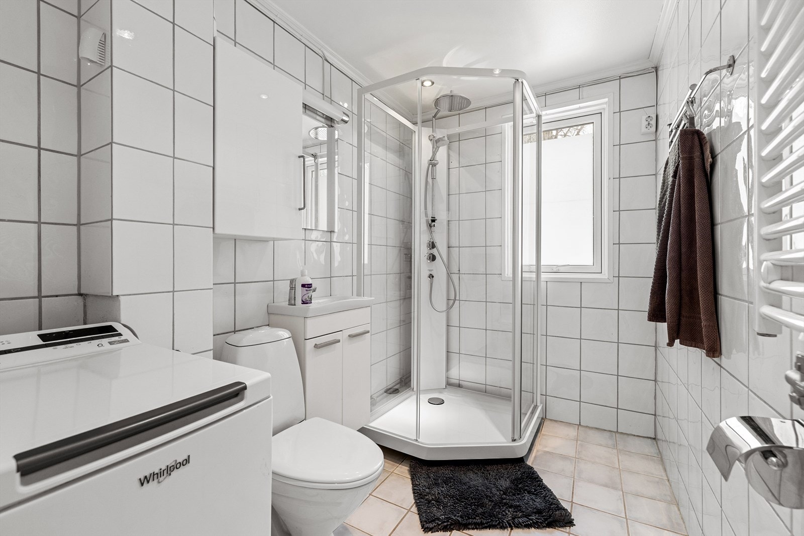 Baderommet er funksjonelt med flislagte overflater som både er stilrene og enkle å vedlikeholde. Galleribilde