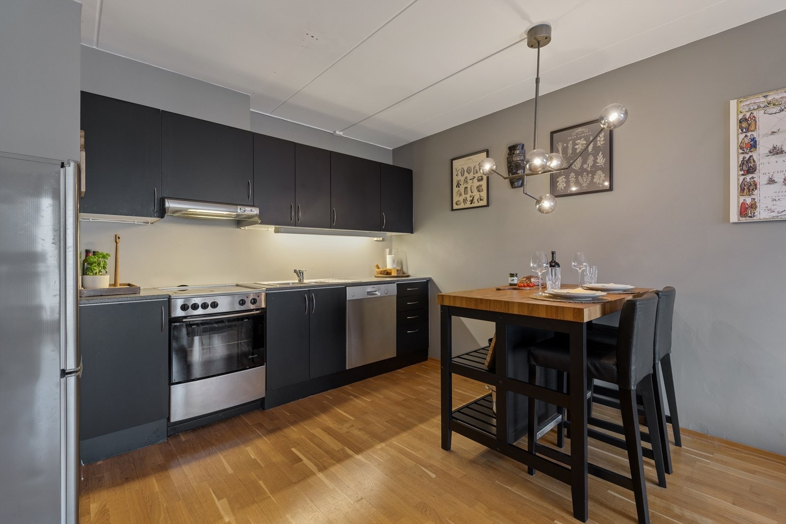 Kjøkkenet er tidløst innredet med grå, slette fronter og grå benkeplate i laminat. Kjøkkenet er ellers utstyrt med frittstående hvitevarer og har kjøkkenventilator med avtrekk koblet til avtrekksanlegget i blokken. Galleribilde