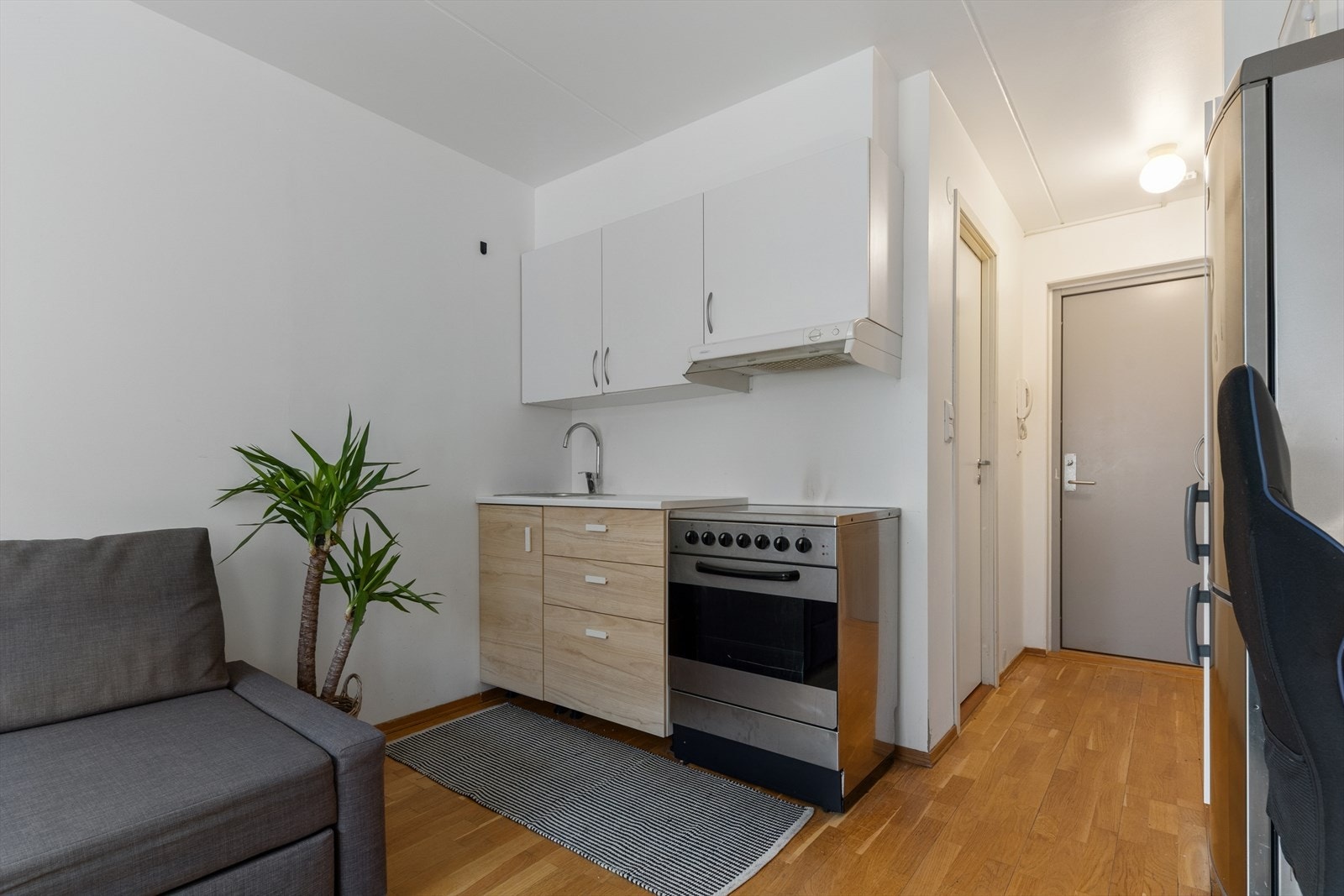 Kjøkkenet fikk ny innredning i 2024 og er stilrent innredet med en kombinasjon av hvite og trefargede fronter og hvit benkeplate i laminat. Galleribilde