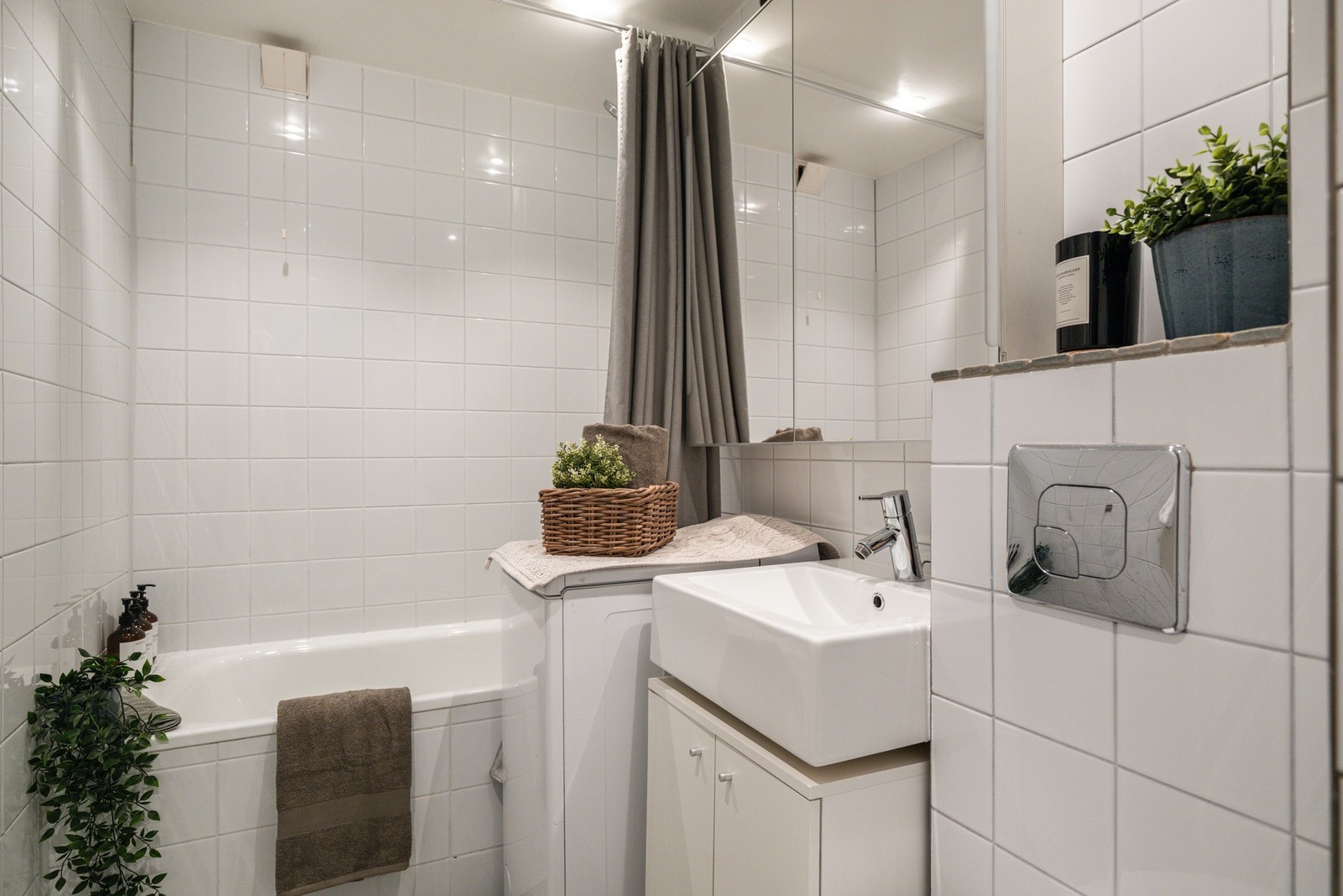 Vegghengt servant av porselen med lyst skap under og vegghengt speilskap over. Galleribilde