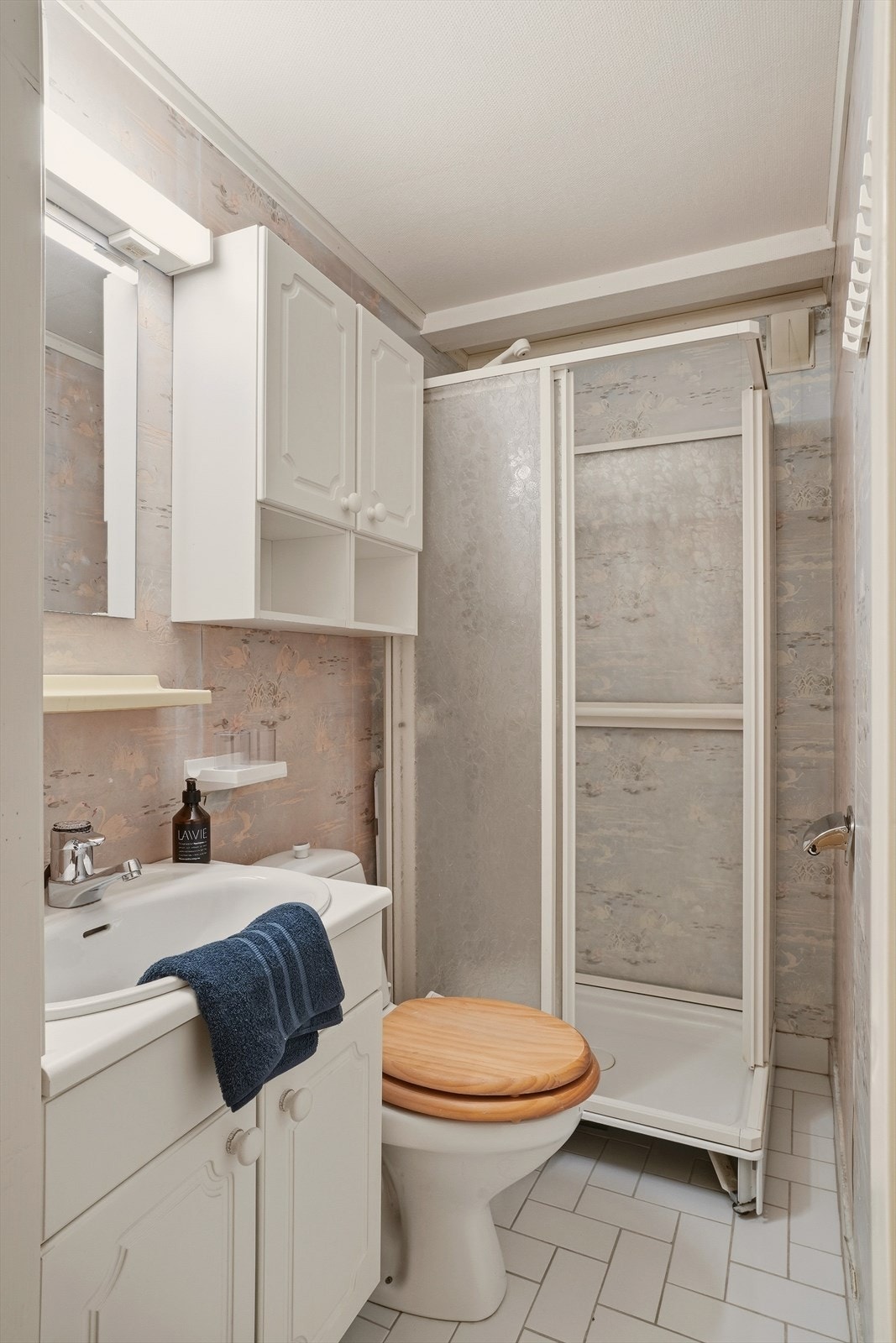 Badet er av eldre dato. Badet inneholder: klosett, vask, dusjkabinett. Galleribilde