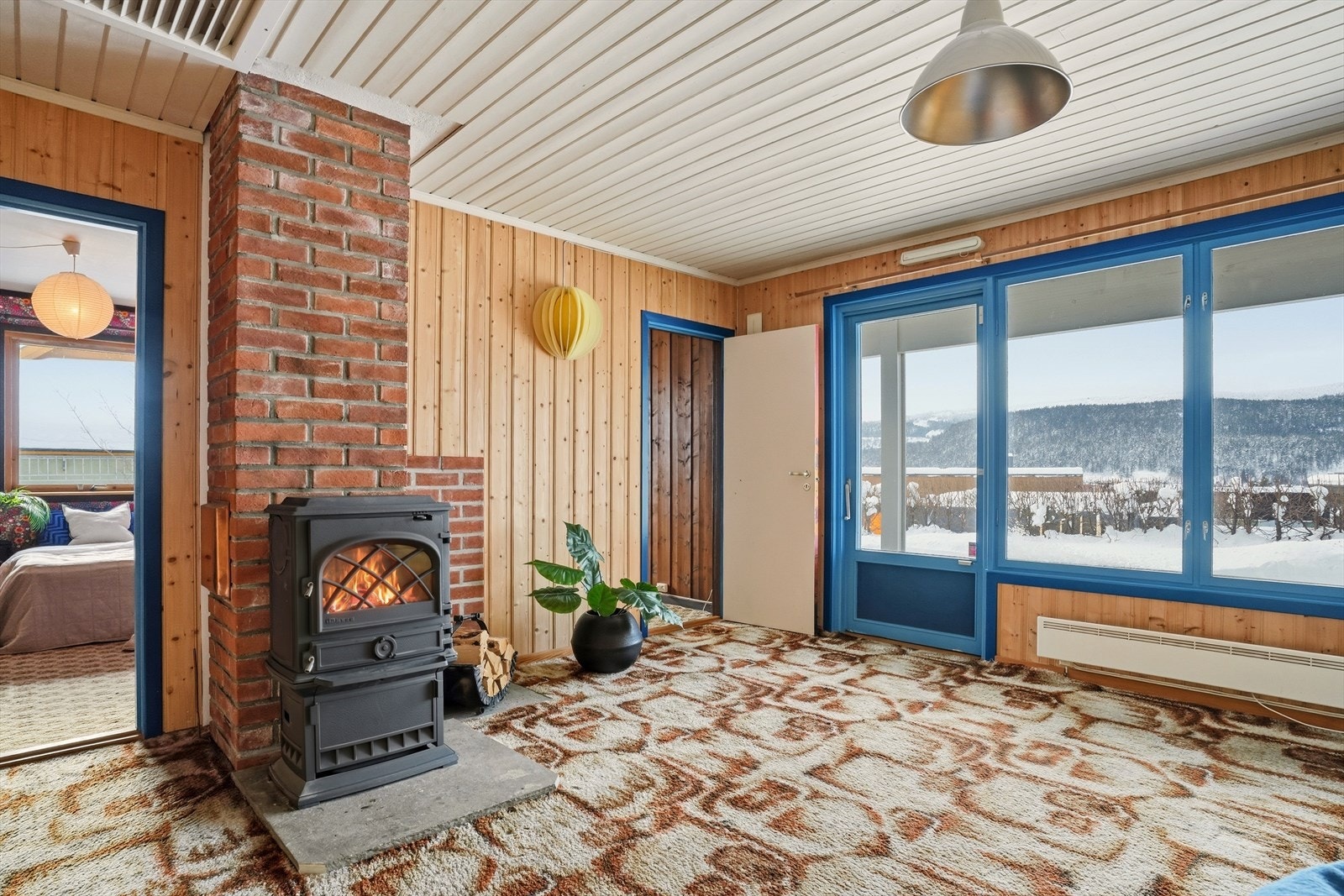 Stuen i kjeller har en varmende vedovn. Galleribilde