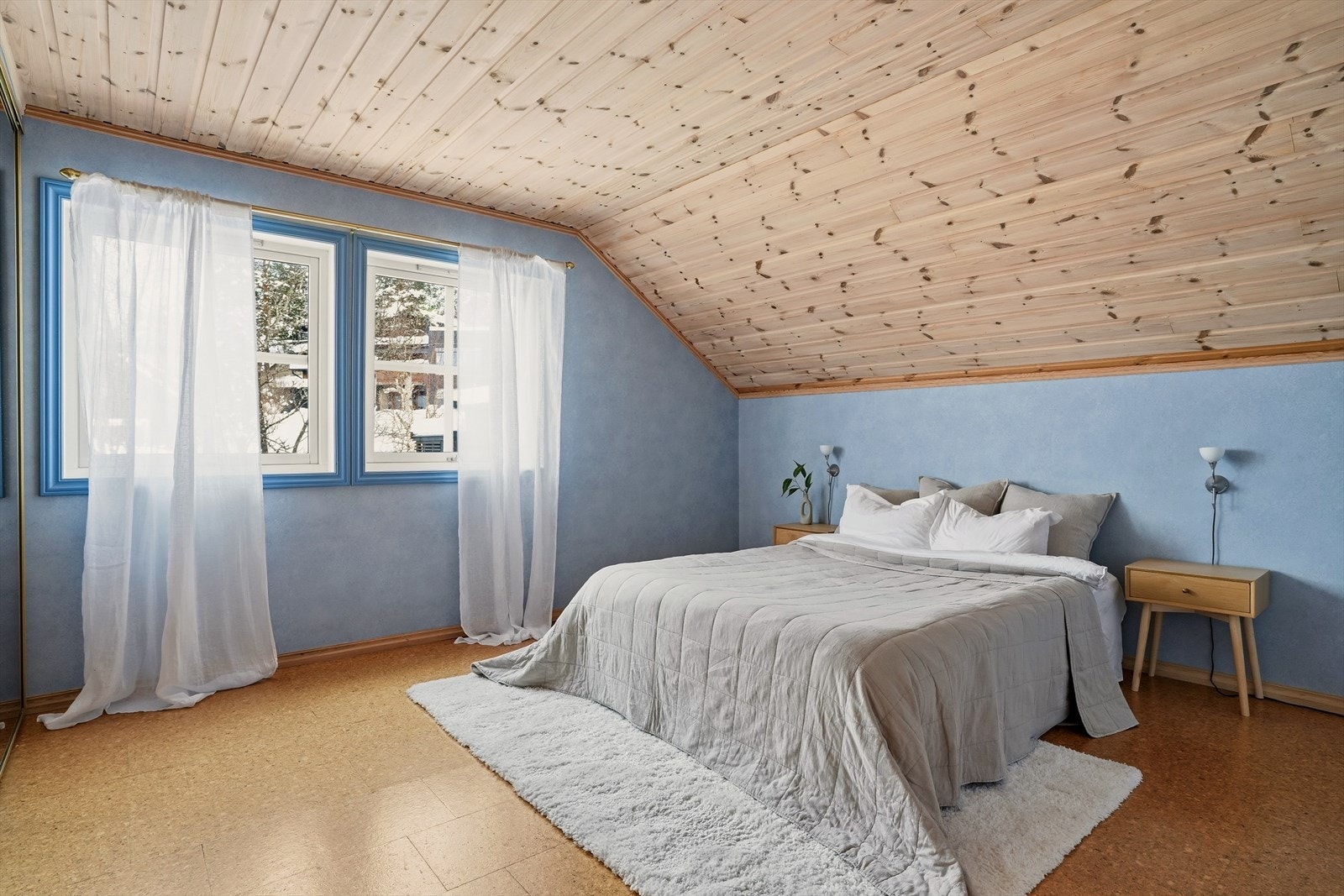 Romslig hovedsoverom i en dus blåtone. Galleribilde