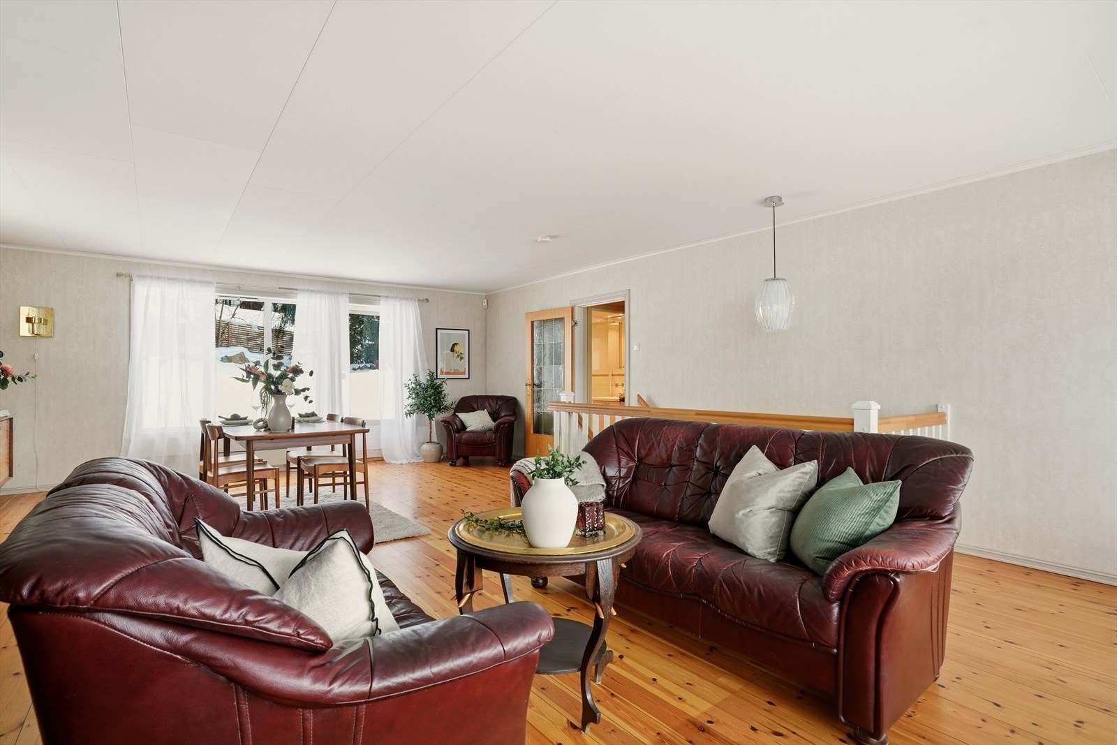 Stuen har lys tapet på vegger og furu gulv. Galleribilde