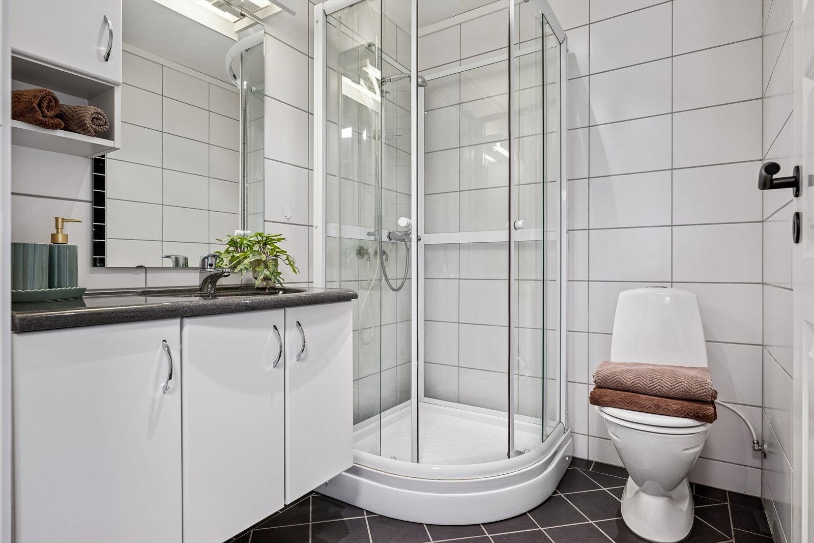 Boligens andre bad er også helfliset med varmekabler og utstyrt med dusjkabinett. Galleribilde