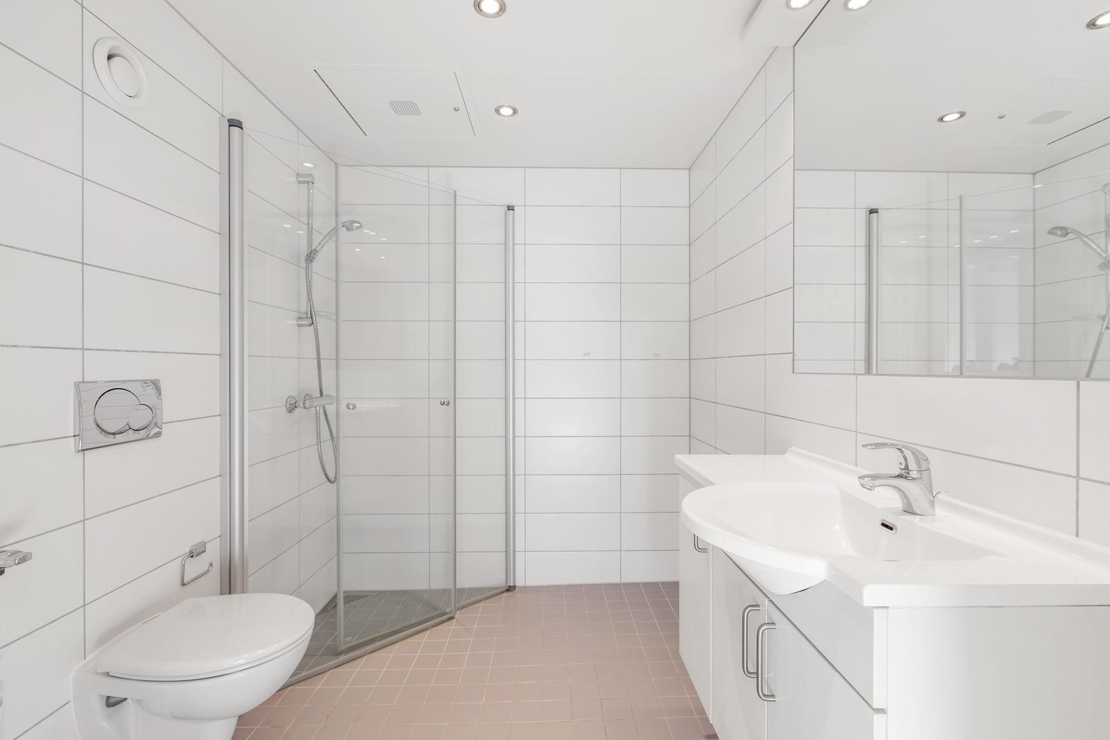 Pent, flislagt bad med opplegg for vaskemaskin og tørketrommel. Galleribilde