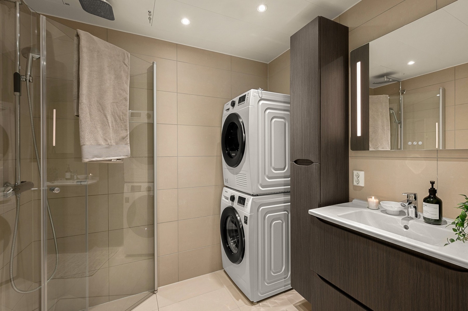 Baderommet er stilfullt, med opplegg for vaskemaskin og tørketrommel. Galleribilde