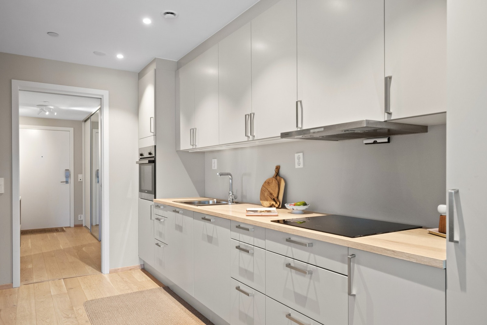 Integrerte hvitevarer og praktisk arbeidsflyt gjør kjøkkenet både funksjonelt og stilrent. Galleribilde