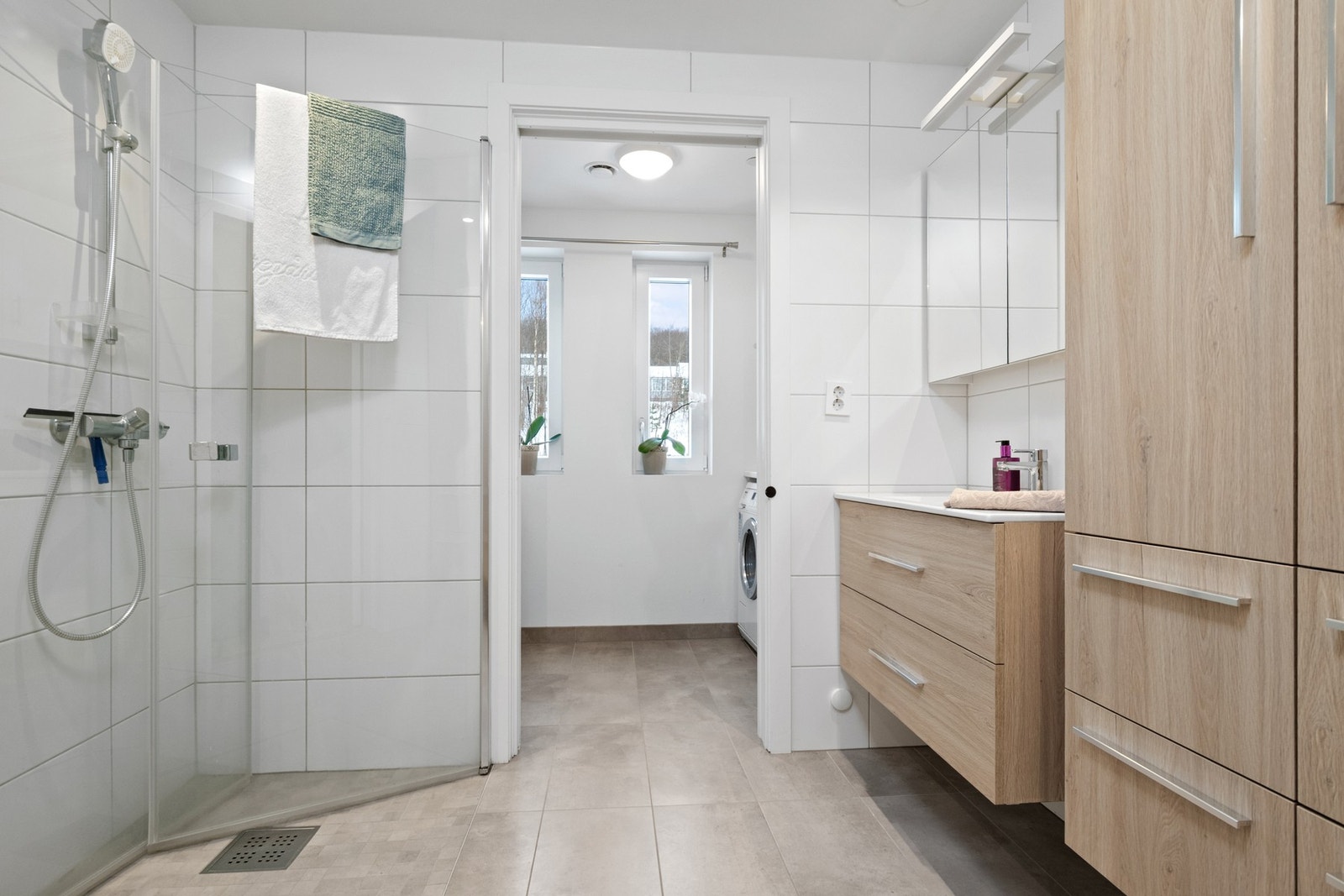 Delikat og moderne bad med flislagte overflater og tidsriktige materialvalg Galleribilde