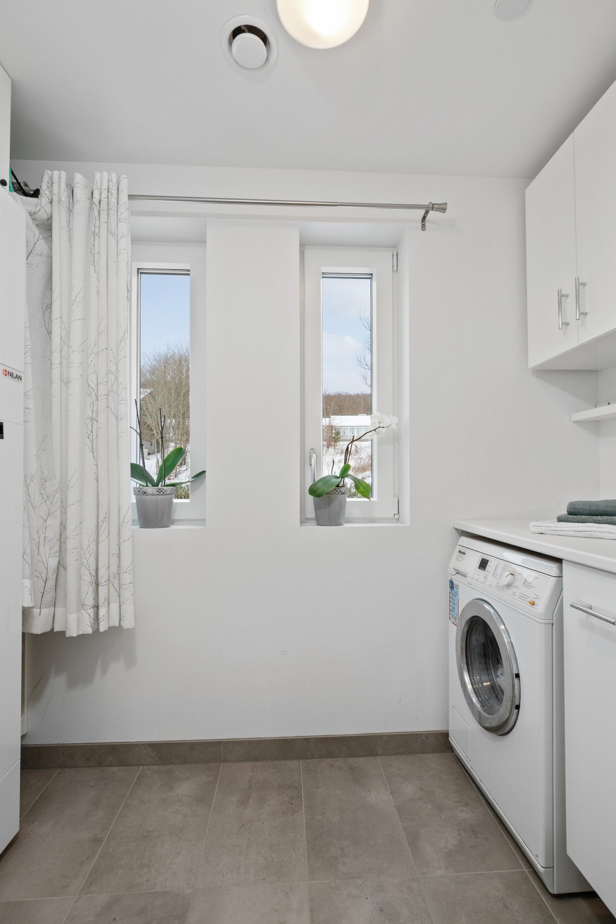 Praktisk innredning med benkeplass og skap for oppbevaring. Et funksjonelt rom som gjør hverdagslogistikken enklere. Galleribilde