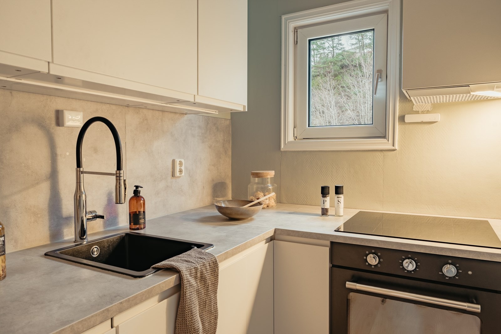 Her er det innredet med slette fronter, laminat benkeplate og praktisk kichenboard over deler av benkeplaten. Galleribilde