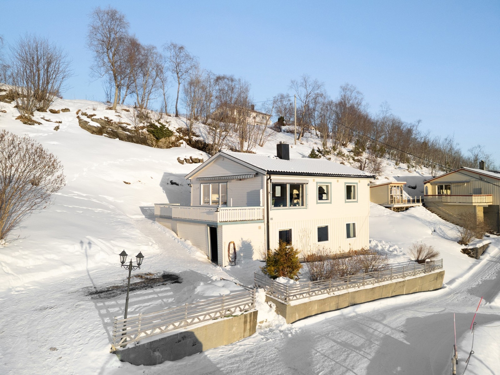 Pent oppbygd med støttemur, gjerde og beplantning Galleribilde