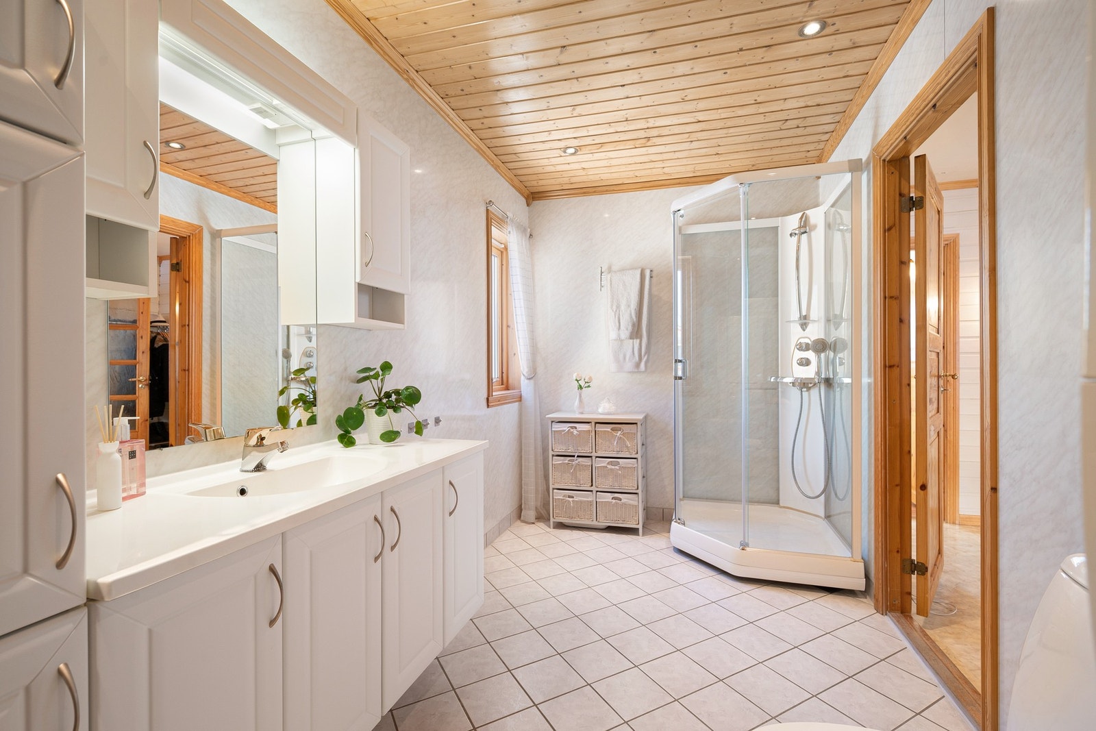 Badet er romslig og inneholder servantinnredning, dusjkabinett og toalett Galleribilde