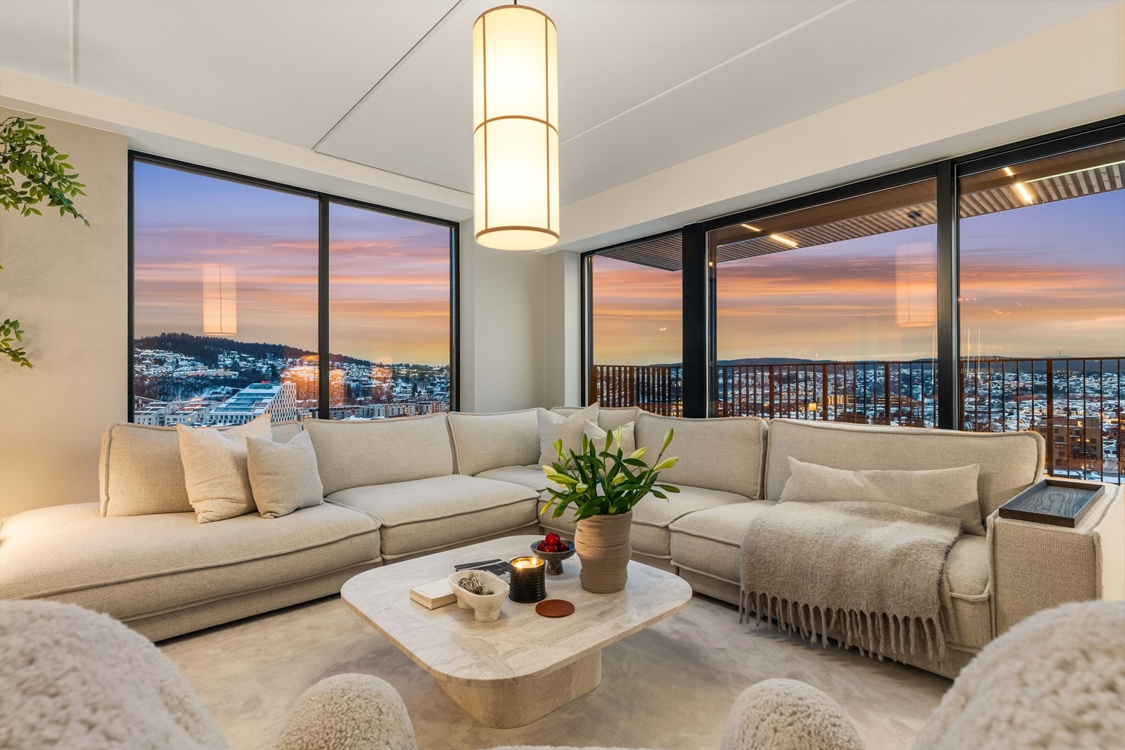 Åpen stue med panoramavinduer som gir en spektakulær ramme rundt byens lys. Et hjem som virkelig imponerer. Galleribilde