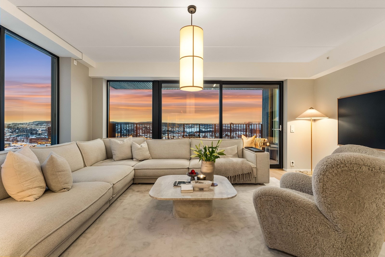 En generøs hjørnesofa inviterer til lange kvelder med utsikt mot solnedgangen. Atmosfæren er lun, luksuriøs og tidløs. Galleribilde