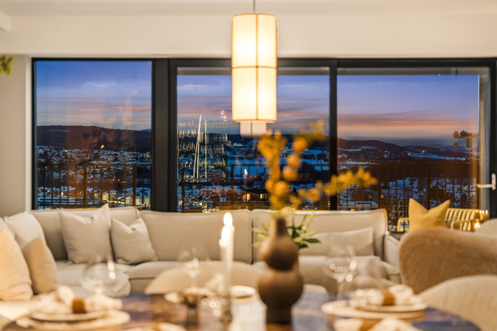 Stemningsfull stue i skumringstimen, hvor byen glitrer utenfor. En unik kombinasjon av ro og urban puls. Galleribilde