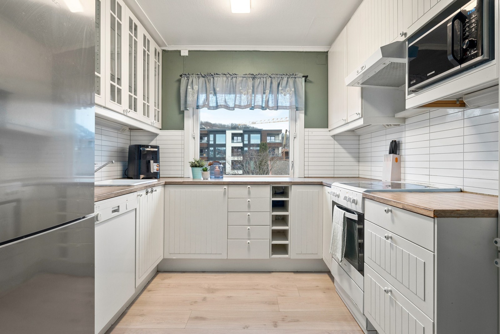 Kjøkkenet har rikelig med skap og benkeplass. Galleribilde