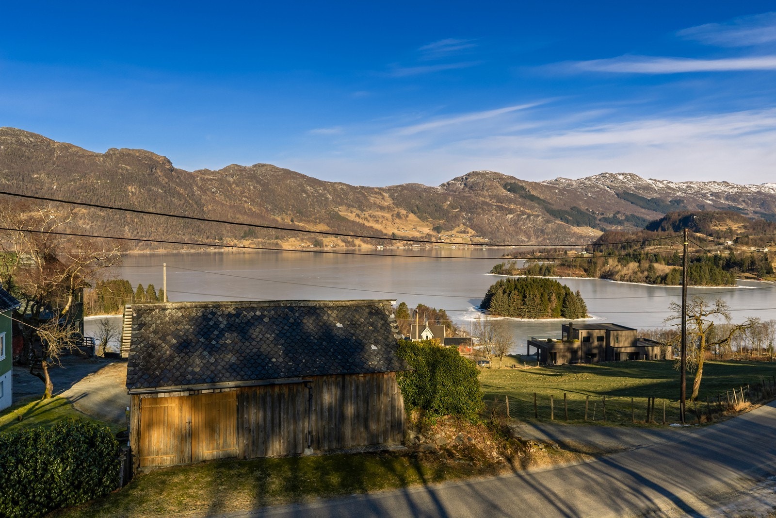 En solrik og skrånet tomt med vakker utsikt til sjø Galleribilde