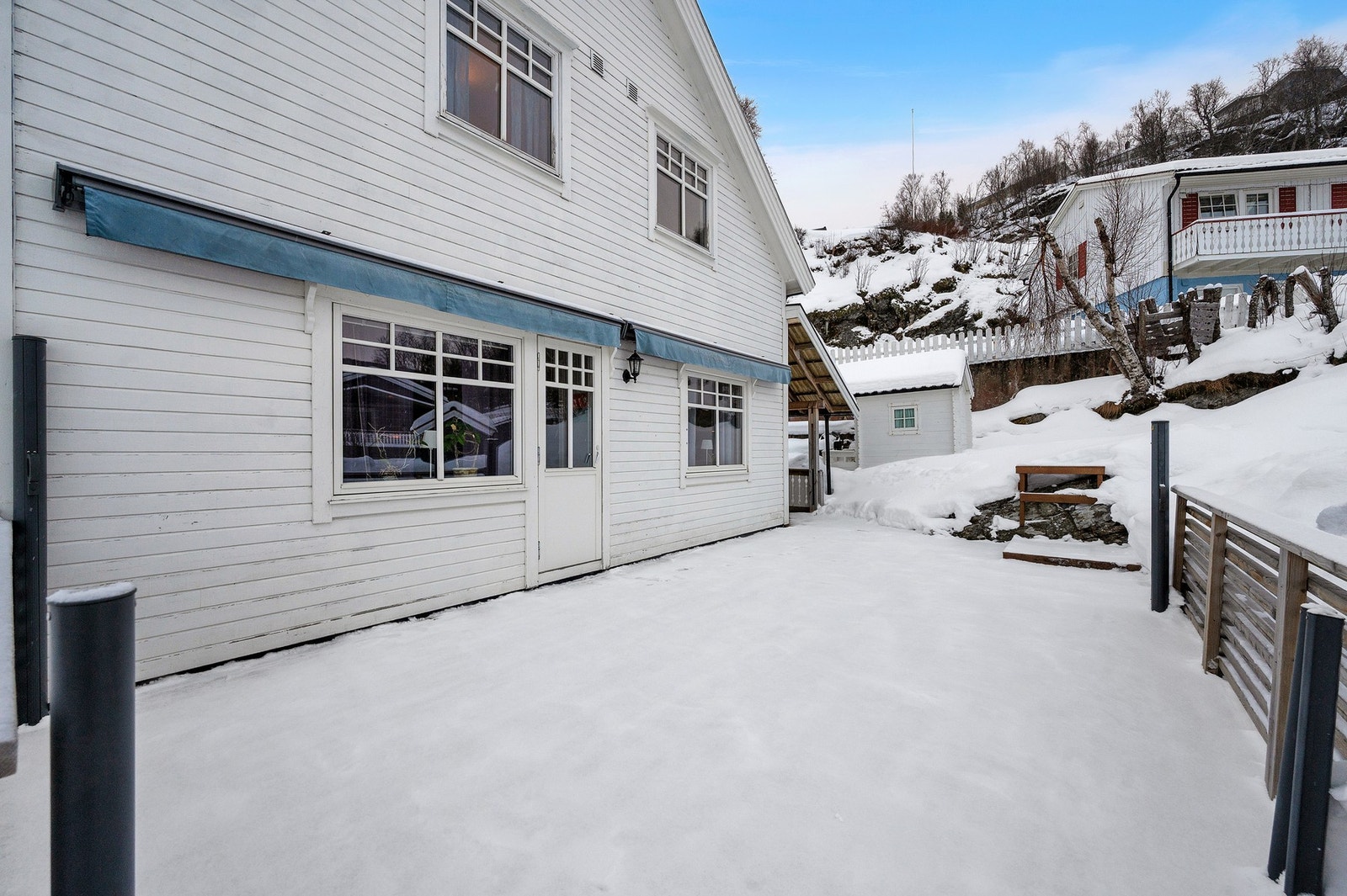 Veranda/uteplass utenfor stue/kjøkken. Markise er kjekt for de varme dagene. Galleribilde